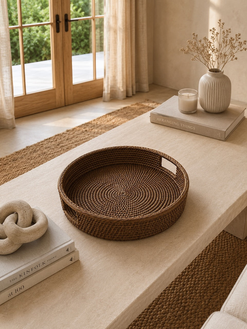 Alden rattan tray on a coffee table with books and decor items in a home setting.