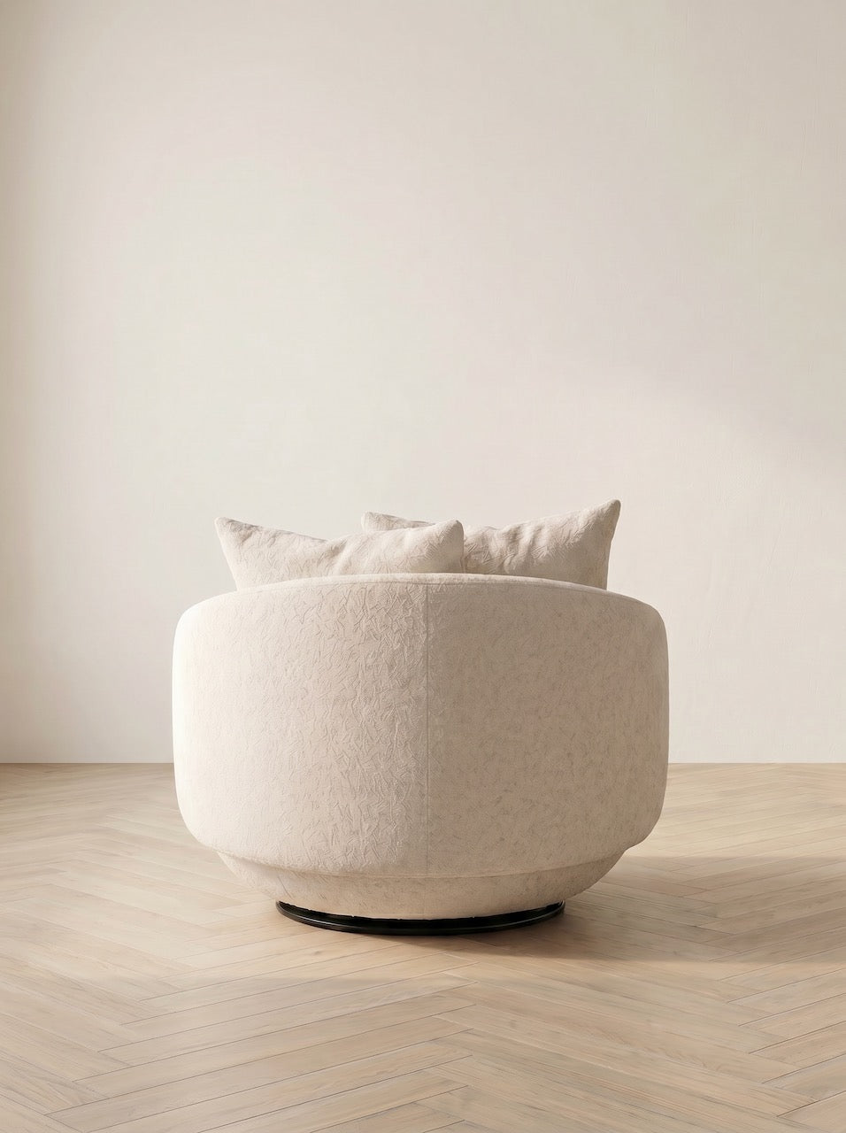 White armchair with cushions on a wooden floor and light-colored wall background
