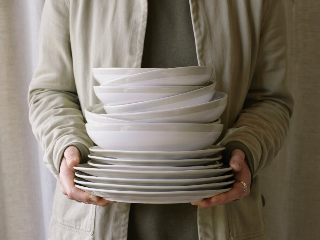 Person holding a stack of Vela Dinner Set 