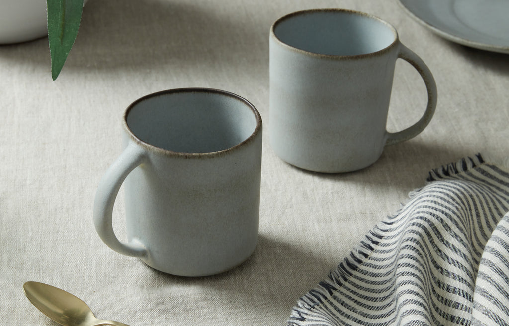Two Azul blue mugs on table 