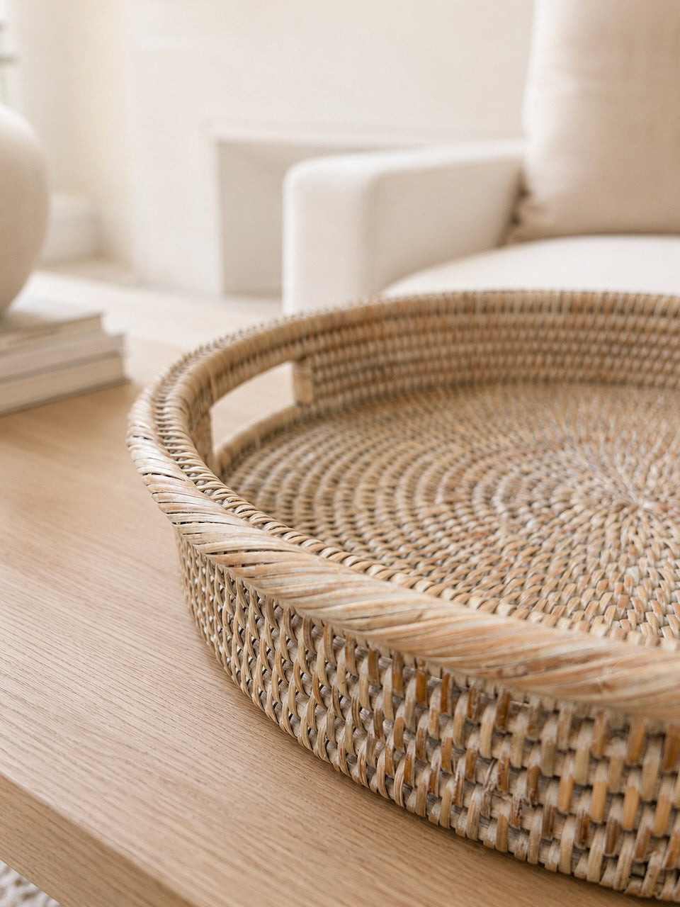 Alden rattan tray on a wooden surface with a blurred background