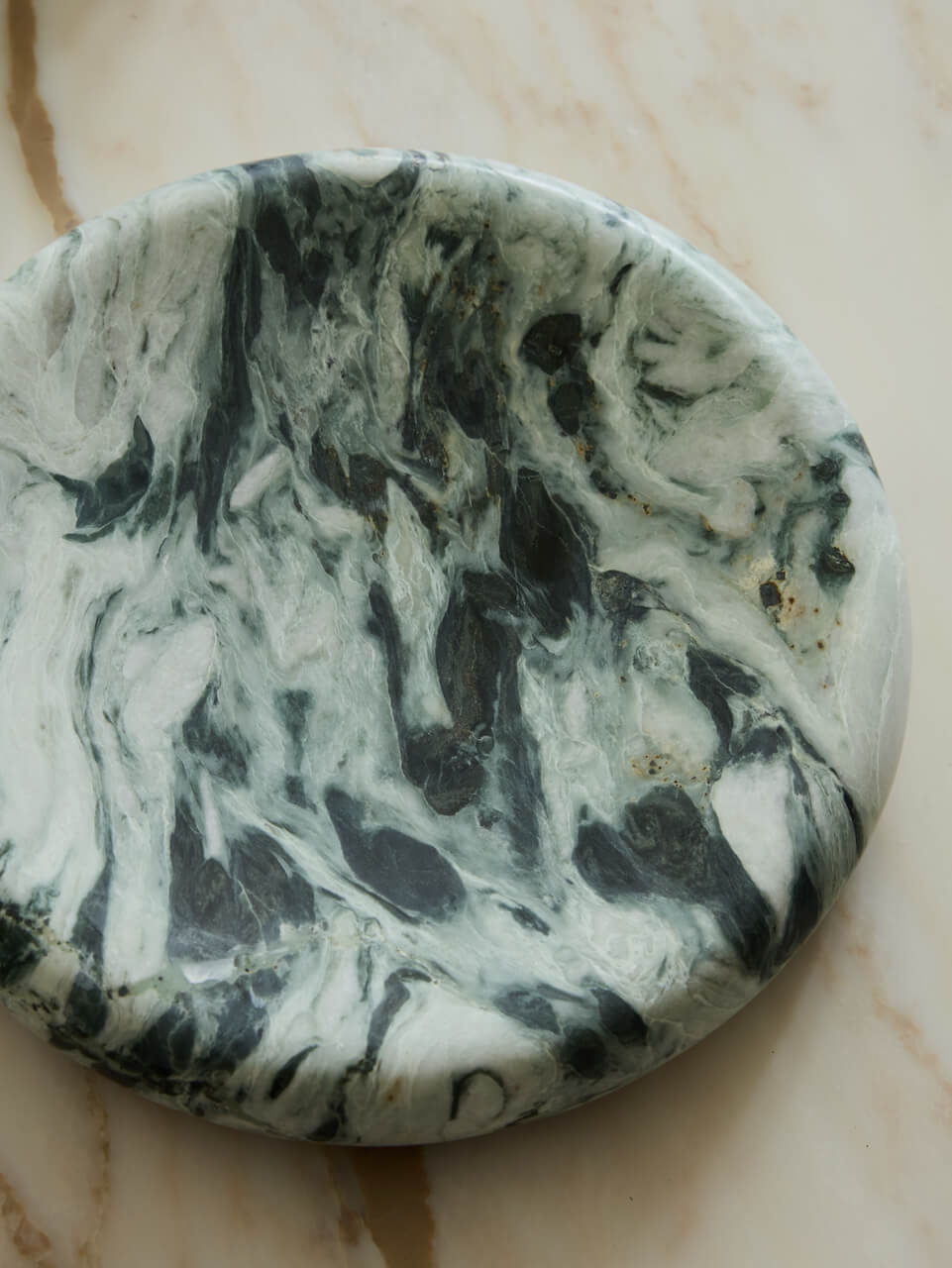 Marble-patterned stone tray on a beige surface