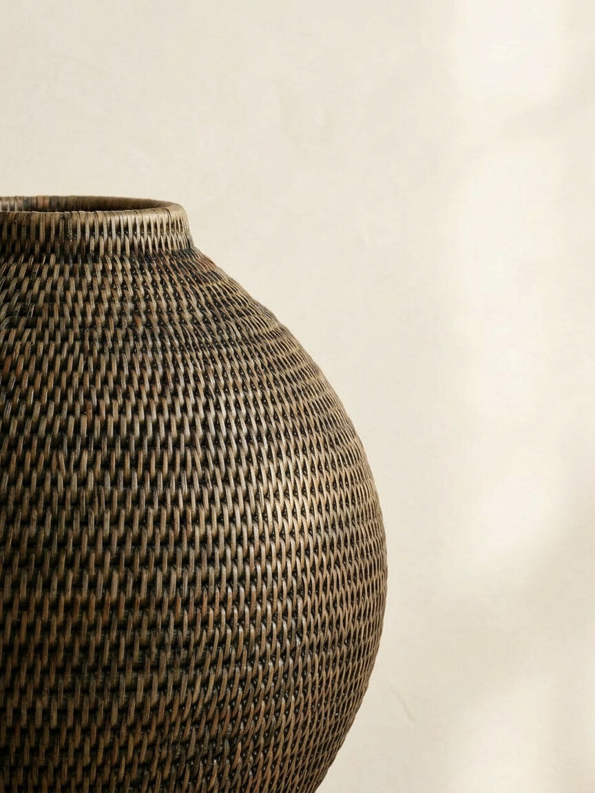 close-up of antique brown handwoven rattan vase showing detailed natural weave texture