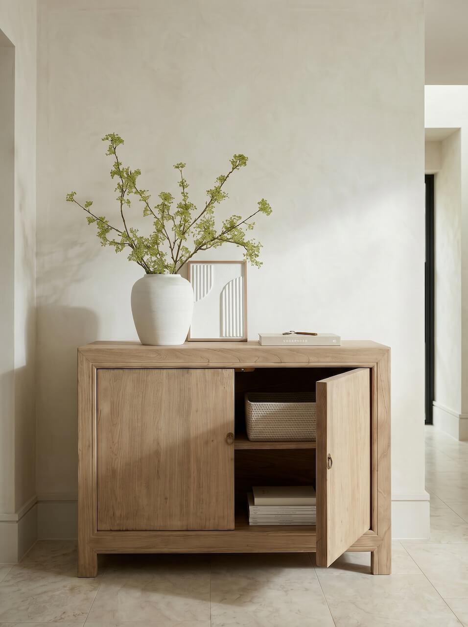 Wooden sideboard with a vase of flowers and books in a minimalistic room.