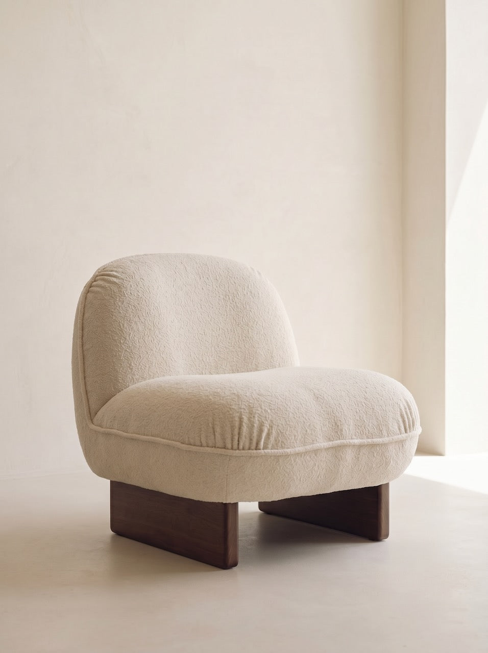 Beige armchair with wooden legs on a neutral background